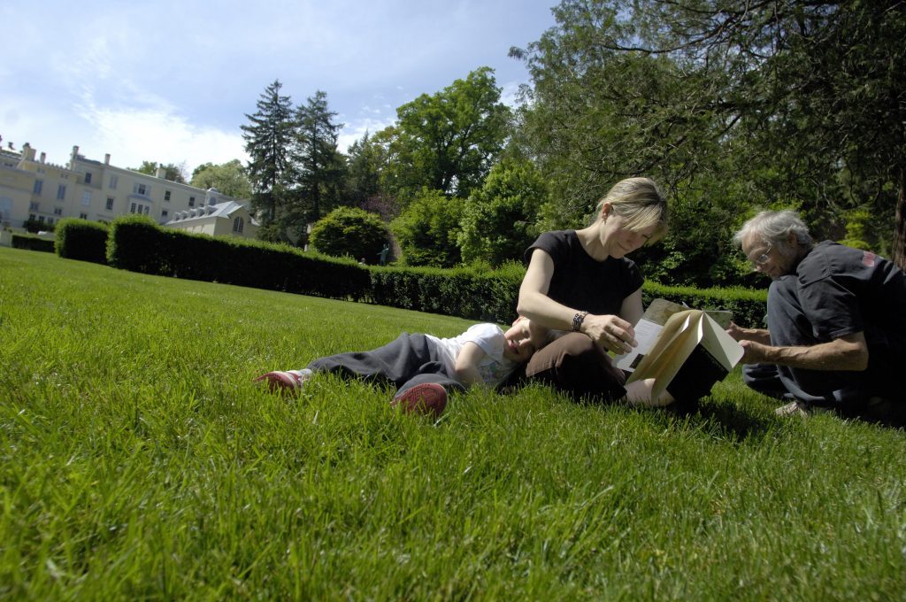 A family reads in the Upper Garden at Evergreen Museum & Library
