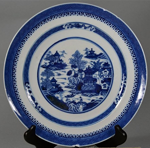 blue and white plate with Chinese scene in center displayed on stand